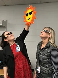 image of two librarians looking at a toy sun
