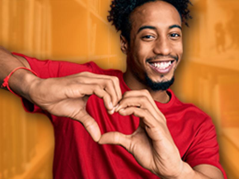 Photo of a young black man making a heart shape with his hands